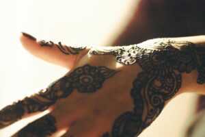 Beautiful henna art on a hand captured in soft, warm light, showcasing intricate details and patterns.